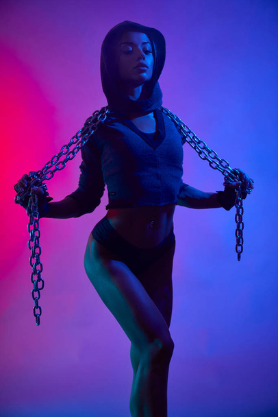 Muscular girl in sportswear holding chain. - Fotó, kép