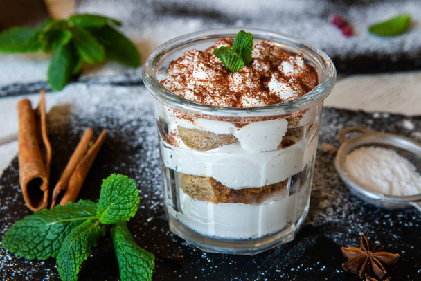 Tiramisu cake in glass, classic Italian dessert with mascarpone cream and cocoa. selective focus. - Photo, Image