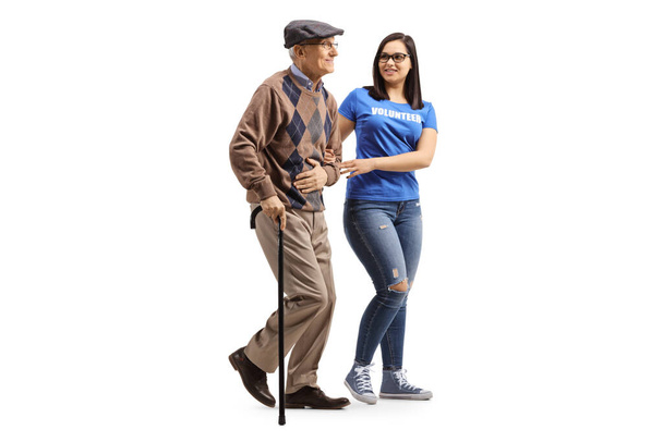 Young female volunteer helping an elderly man with a walking can - Fotoğraf, Görsel