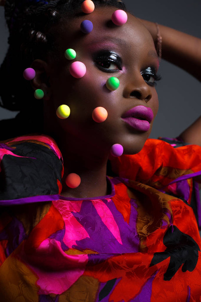 Művészeti portré fényes ruhában szürke háttérrel a stúdióban. Közelkép szépség portré afrikai nő kreatív smink stúdióban. - Fotó, kép