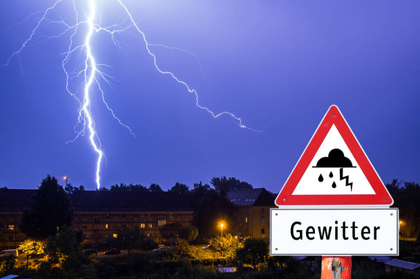 lightning storm in the evening with city lights german warning s - Photo, Image