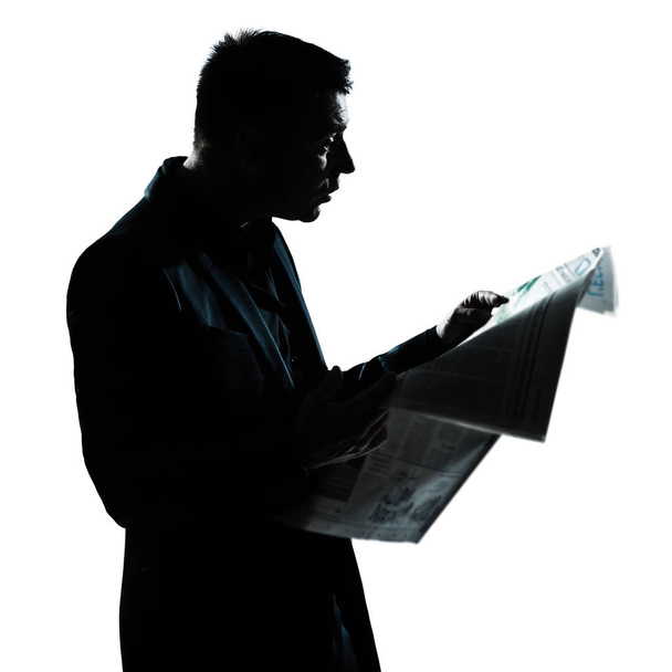 one caucasian man portrait silhouette reading newspaper in studio isolated on white background - Fotoğraf, Görsel