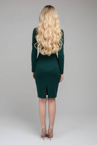 Vista posteriore di attraente donna bionda con capelli lunghi biondi ricci in abito da sera
 - Foto, immagini