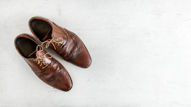 Top down view, worn classic dark brown brogue shoes on white boa - Foto, imagen