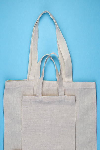 Reusable textile bag on blue background. Zero waste concept. - Фото, изображение