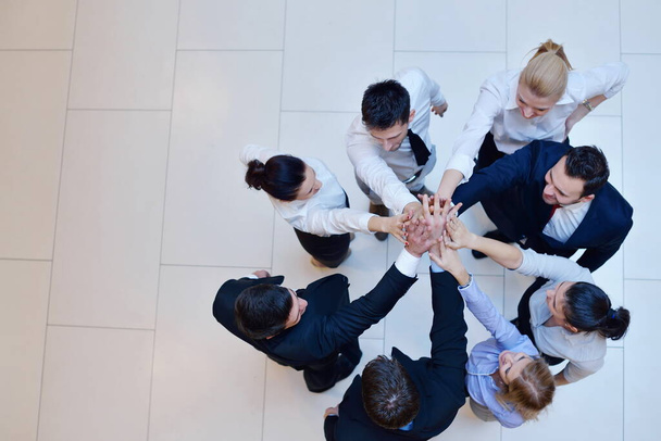 los empresarios se agrupan uniendo sus manos y permanecen como equipo en círculo y representando el concepto de amistad y trabajo en equipo - Foto, Imagen
