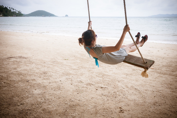 Szczęśliwa dziewczyna Azji na huśtawce na plaży - Zdjęcie, obraz