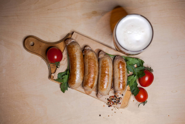 Fried sausages with a glass of light beer (top view) - Фото, зображення