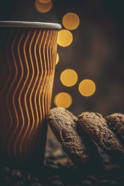 Cups and cups with coffee, coffee grains and gingerbread cookies nearby for refreshments in warm home colors - Foto, Imagem