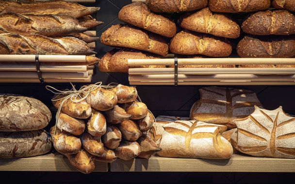 Συλλογή ψωμιού σε ξύλινα ράφια αρτοποιίας. Ψωμί - Φωτογραφία, εικόνα