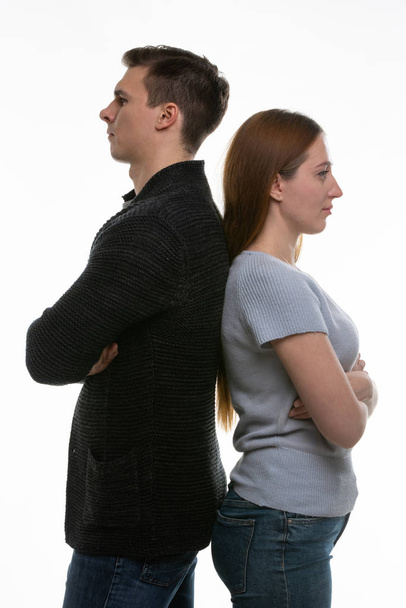 Mężczyzna i kobieta stoją plecami do siebie, z rękami złożonymi na piersiach. - Zdjęcie, obraz
