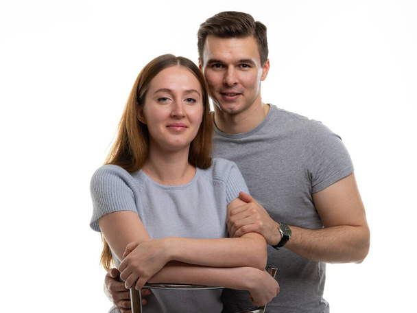 Portrait of a happy and cheerful young couple, a guy hugs a girl - Fotó, kép