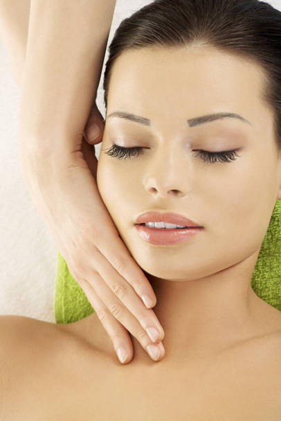 Beautiful young relaxed woman enjoy receiving face massage therapy at spa saloon - Φωτογραφία, εικόνα