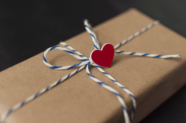  茶色いクラフト紙と赤いハートのバレンタインデーギフトボックス. - 写真・画像