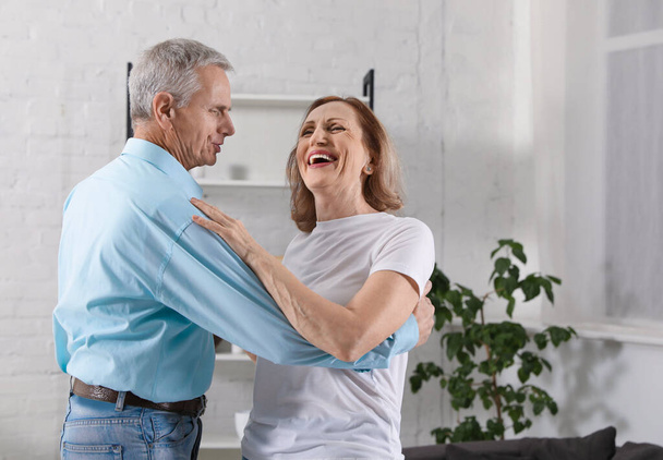 Happy senior couple dancing together at home - Foto, Imagem