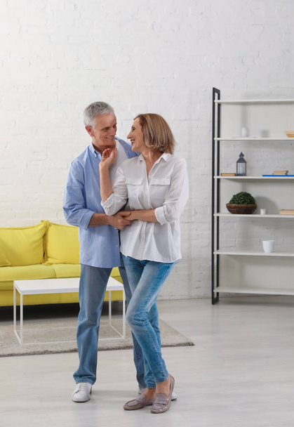 Happy senior couple dancing together in living room - Photo, Image