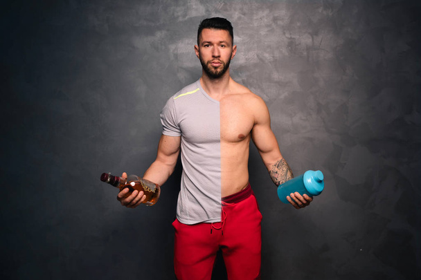 Concepto de estilo de vida saludable - retrato de un hombre caucásico musculoso sin camisa sosteniendo una botella de alcohol y una botella de agua
 - Foto, Imagen