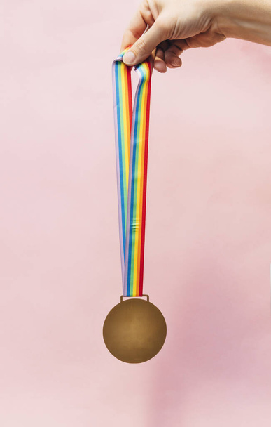 Medal with colorful ribbon hung in hand - Photo, Image