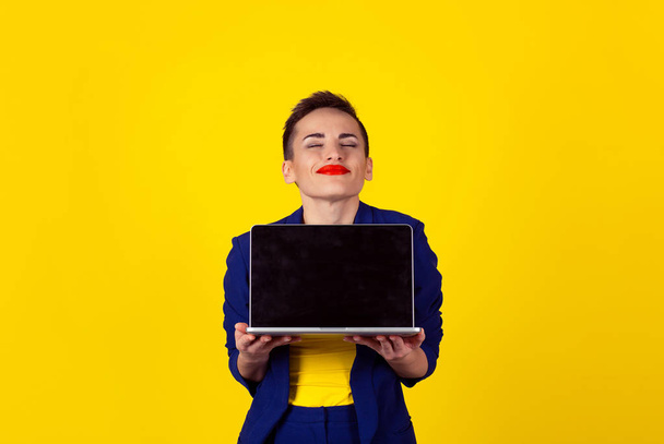 Love for laptop. Closeup portrait happy smiling businesswoman, corporate employee, insurance agent  holding computer isolated background office yellow background. - Foto, immagini
