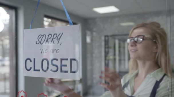 mały biznes, szczęśliwy menedżer kobieta w okularach do zmiany wzroku zamknięte, aby otworzyć znak na oknie uśmiechnięty patrząc na zewnątrz czeka na klientów, startup - Materiał filmowy, wideo