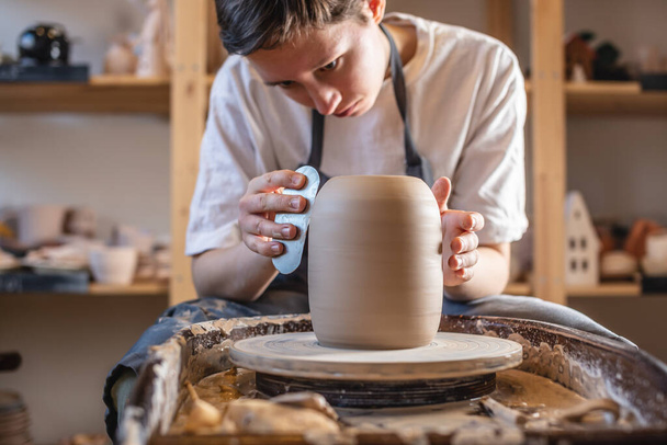 Potter travaille sur une roue de Potter faisant un vase. Traitement maître de la cruche formée lui donnant la forme correcte
 - Photo, image