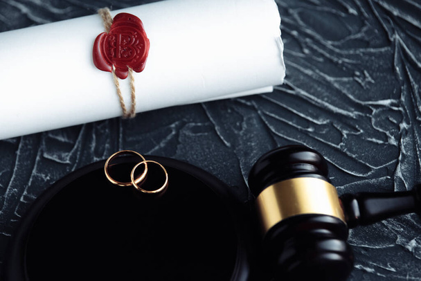 2 つの壊れた黄金結婚指輪は離婚判決文書です。離婚および分離の概念 - 写真・画像