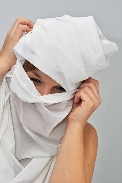 young woman in a mask on a white background - Foto, afbeelding