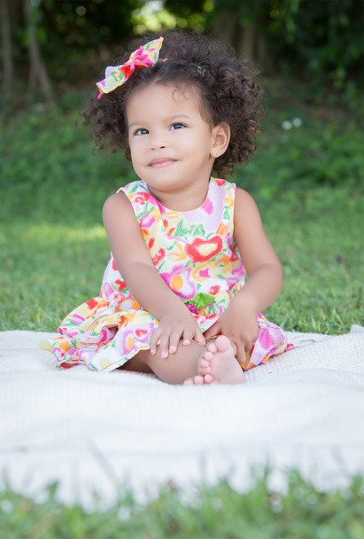 Small latin girl on a green grass park - Фото, зображення
