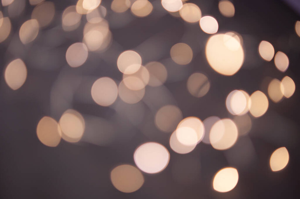 The background is a golden bokeh of the glare of garland lights. Defocus - Zdjęcie, obraz