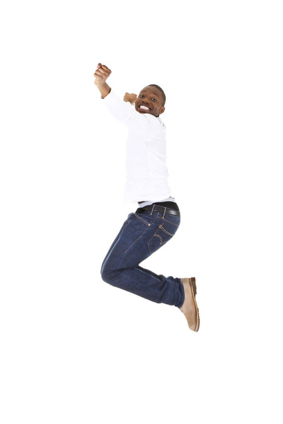 Young happy afro american man jumps in joy over white background.  - 写真・画像