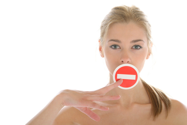 Woman holds prohibiting sign before mouth - Fotoğraf, Görsel