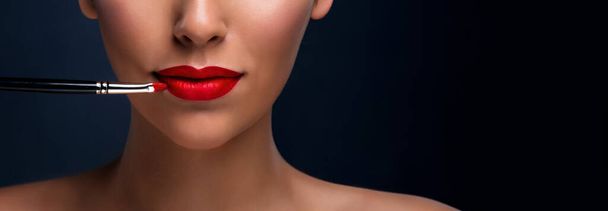 Sluiten van rode mat lippen met cosmetische borstel. Beroepssamenstelling - Foto, afbeelding