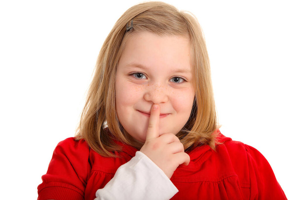 the photo shows a young girl who has put his index finger to his lips and apparently has a secret - Zdjęcie, obraz