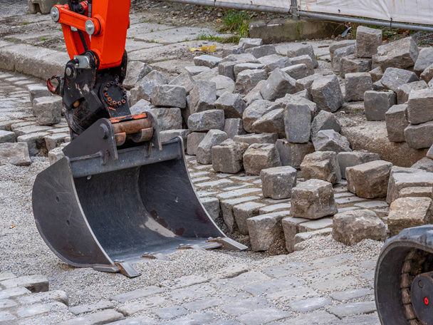Construcción de carreteras adoquines jardinería con una excavadora
 - Foto, imagen