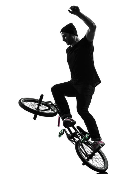 one caucasian man exercising bmx acrobatic figure in silhouette studio isolated on white background - Foto, afbeelding