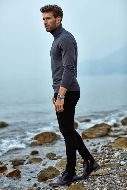 Handsome man in autumn outfit relaxing on the beach  - Foto, afbeelding