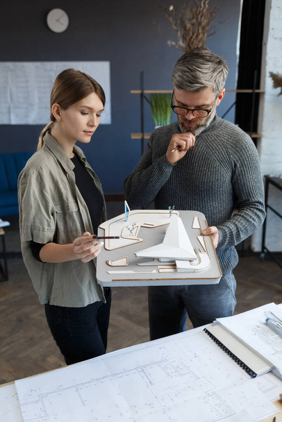 3d architects team working in office with building 3d model. Architects inspect building layout, planning construction project, searching new ideas. Partners discussing at work. Business concept - Foto, Imagen