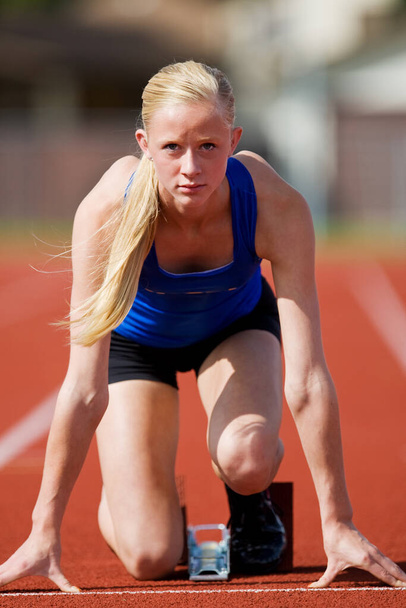 A teenage track athlete in the starting blocks  - Fotografie, Obrázek
