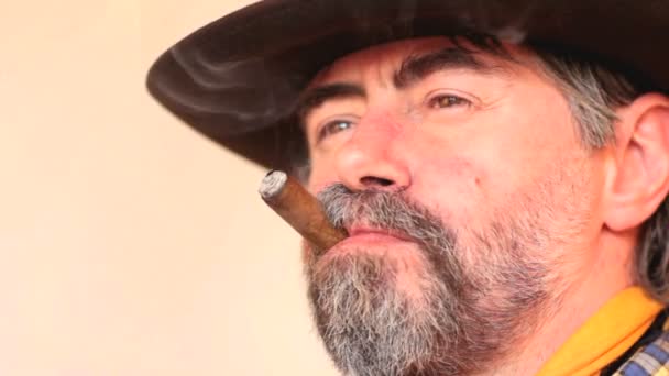 Nahaufnahme Porträt eines Cowboys, der den Kopierraum betrachtet, Zigarre raucht und lacht. - Filmmaterial, Video
