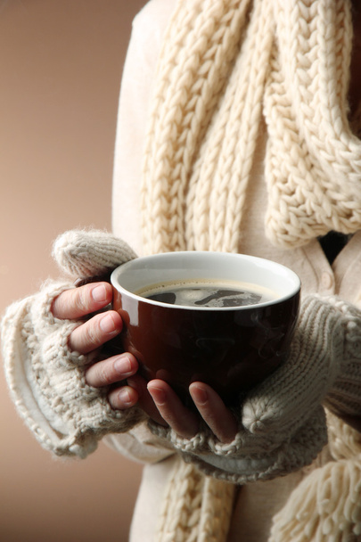 Female hands with hot drink, on color background - Foto, imagen