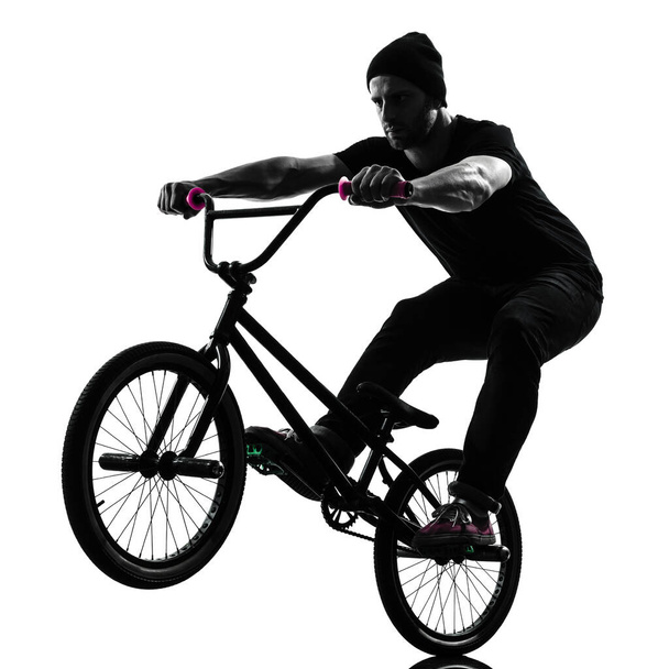 one caucasian man exercising bmx acrobatic figure in silhouette studio isolated on white background - Фото, зображення