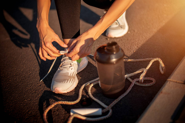 Закройся, фитнесс-женщина, завязывающая шнурки
. - Фото, изображение