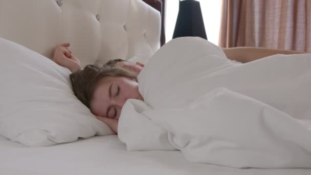 Man embracing girlfriend while sleeping under blanket - Кадры, видео