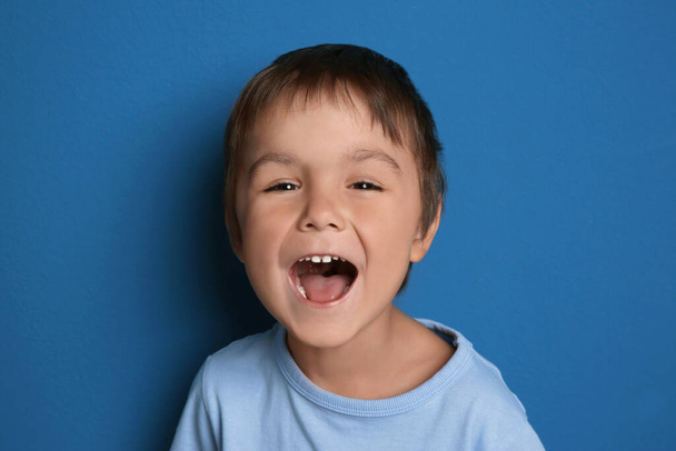 Portrait of excited little boy on blue background - Foto, imagen