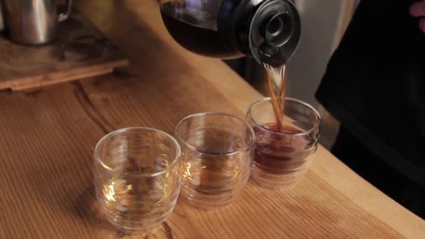 Barista ír kávét főz. Kávé öntése csészékbe közelről. - Felvétel, videó