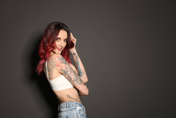 Beautiful woman with tattoos on body against black background. Space for text - Fotografie, Obrázek