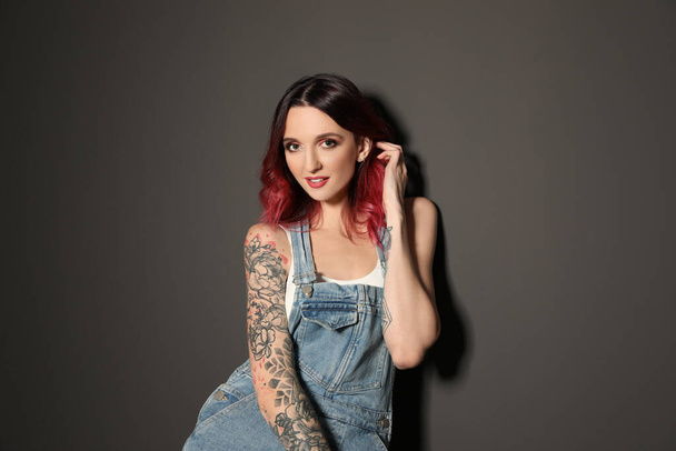 Beautiful woman with tattoos on body against black background - Foto, Bild