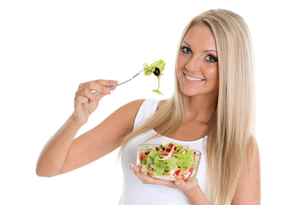 Slender young woman holds a bowl of salad  on a white background. Concept of healthy lifestyle. - Fotografie, Obrázek