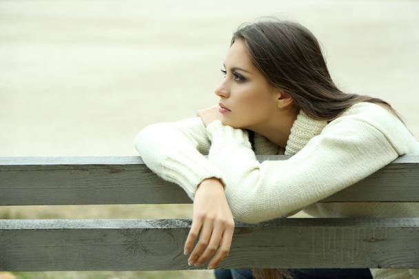 公園のベンチに孤独な若い女性 - 写真・画像