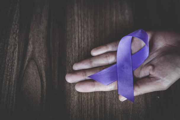 Purple ribbon in a woman's hand, Domestic Violence Awareness Mon - Photo, Image